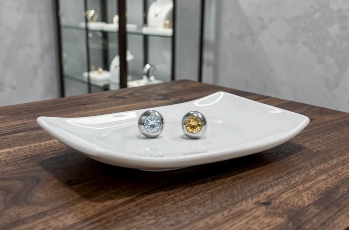 Boucles d'oreilles contemporaines Torrente sur plateau en céramique blanche dans une boutique de luxe